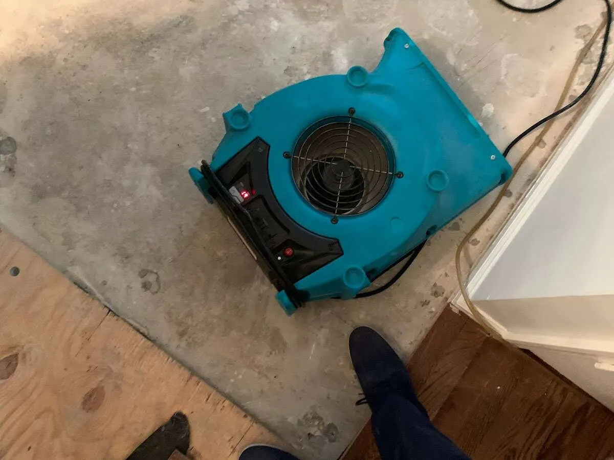 Air mover drying subfloor during Commercial Water Damage Restoration in Lower Salford